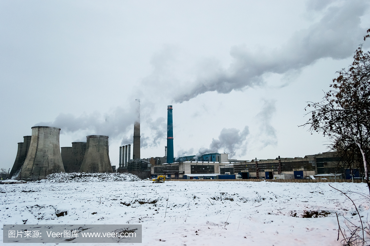 在一个寒冷的冬天,来自几个燃煤电厂的严重空气污染,高高的烟囱在日落时释放烟雾——罗马尼亚的布加勒斯特